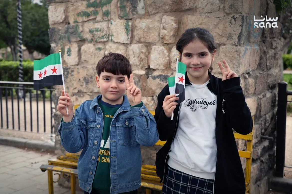 متطوعون بحماة يوزعوا أعلام على الأطفال بذكرى الثورة السورية